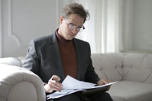 Professional in gray suit reviewing financial documents